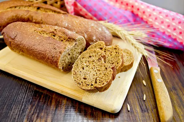 Rogge stokbrood met een mes en een rieten mand — Stockfoto