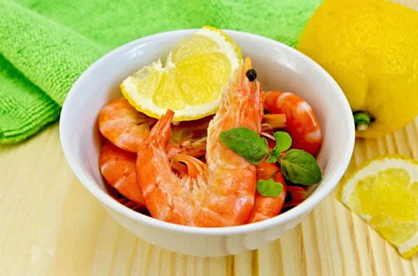 Shrimp in a white bowl with lemon slices — Stock Photo, Image