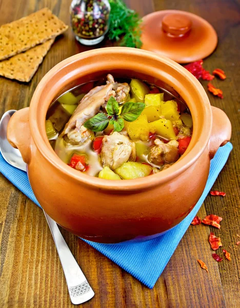 Roast chicken in a clay pot on a board — Stock Photo, Image