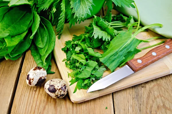 Sorrel and nettles chopped on the board with quail eggs — Stock Photo, Image