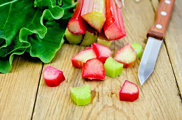 Rhubarb cut with a knife on a board