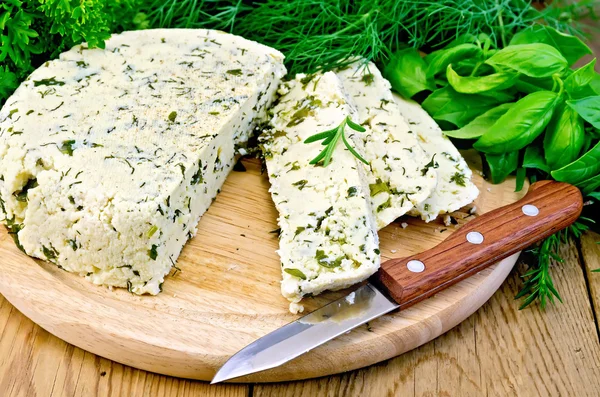 Çeşniler ve bir bıçak ile ev yapımı peynir yuvarlak — Stok fotoğraf