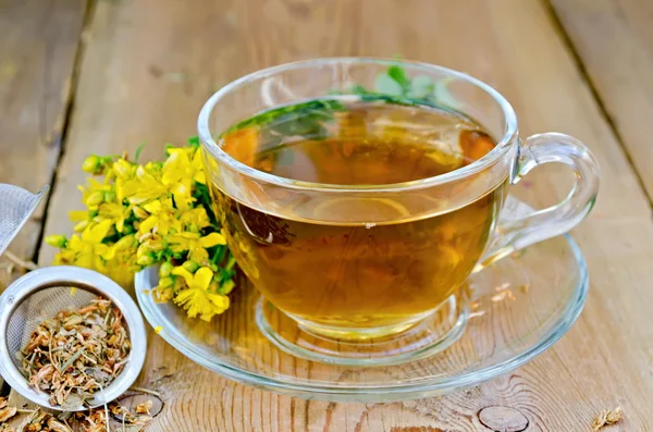 Herbal tea from tutsan in strainer with cup — Stock Photo, Image