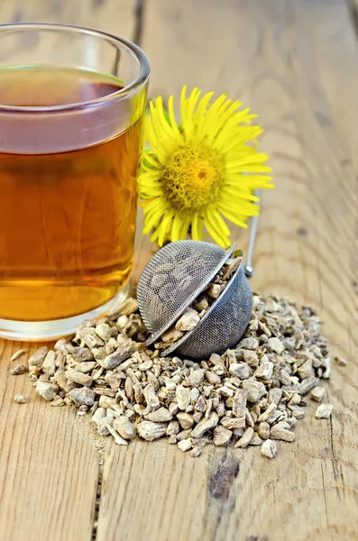 Kräutertee aus der Wurzel von elecampane in einem Sieb mit einem Becher — Stockfoto