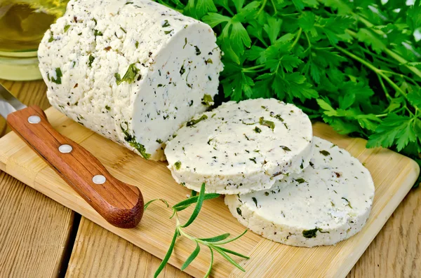 Käse hausgemacht mit Kräutern auf einem Brett geschnitten — Stockfoto