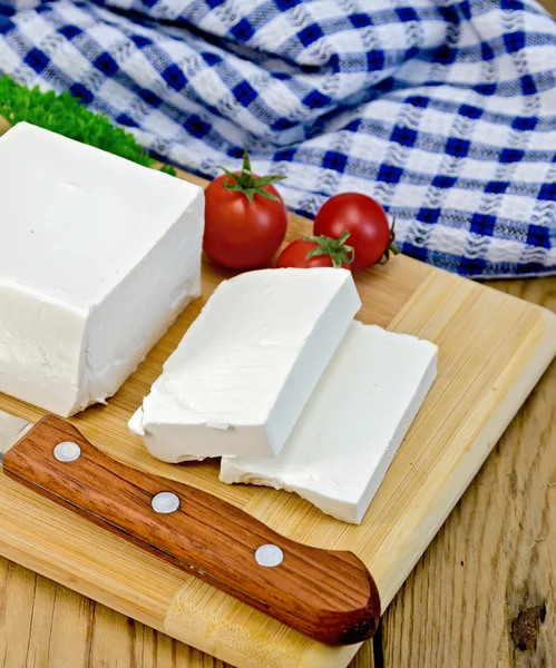 Beyaz peynir ile yönetim kurulu ve peçete üzerinde domates — Stok fotoğraf