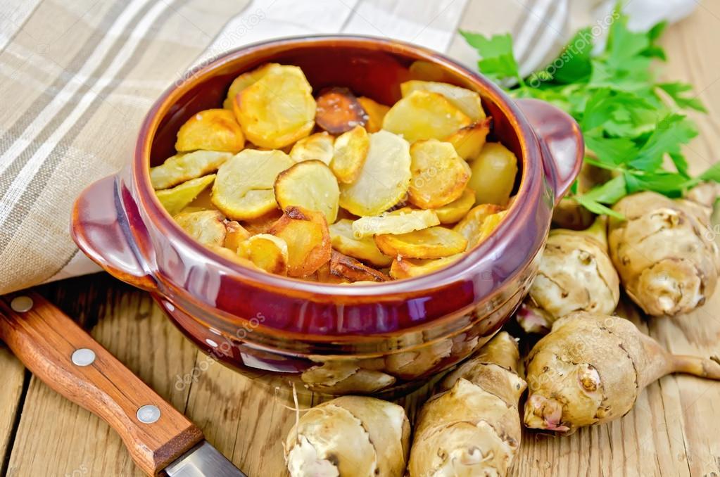 Jerusalem artichokes fried with parsley in pottery Stock Photo by
