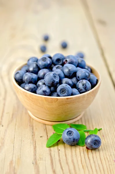 Blueberries in a wooden bowl on the board — Stock Photo, Image