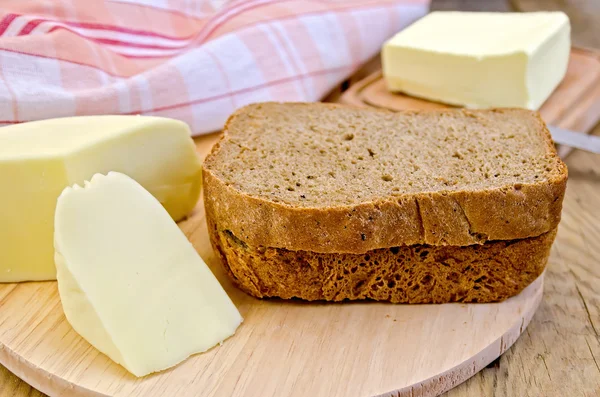 Rye bread with cheese and butter on board — Stock Photo, Image