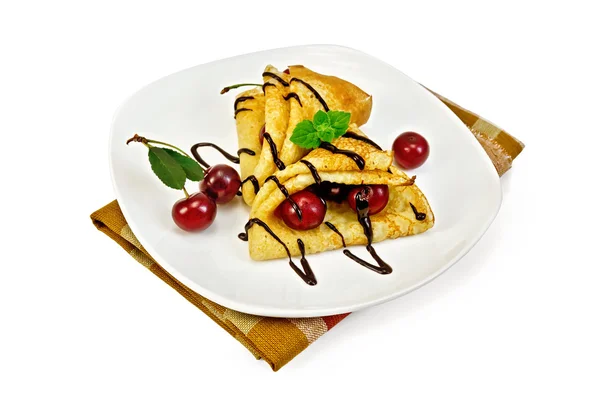 Pancakes with cherry and chocolate syrup on a napkin — Stock Photo, Image