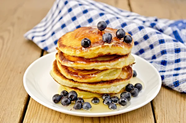 Flapjacks with blueberries and a napkin on the board — Stock Photo, Image