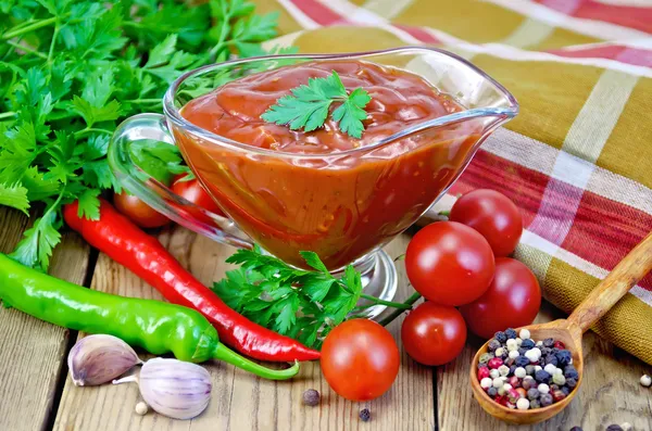 Ketchup in una barca di vetro sugo con verdure sulla tavola — Foto Stock