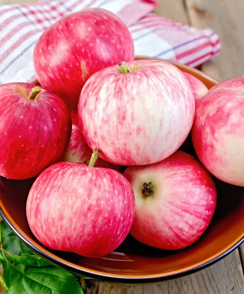 Pommes rouges dans un bol sur la planche — Photo