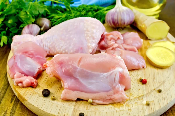 Chicken leg cut on a wooden board with ginger — Stock Photo, Image