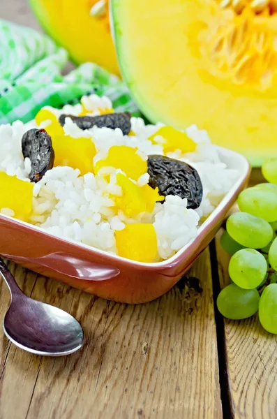 Rice with pumpkin and prunes on the board — Stock Photo, Image