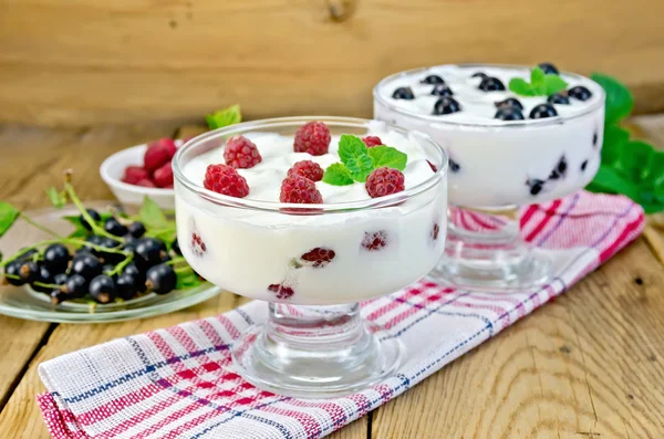 Yogur espeso con grosella negra y frambuesa en el tablero —  Fotos de Stock