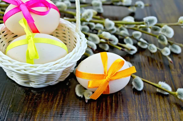 Uova di Pasqua con nastri colorati su una lavagna — Foto Stock