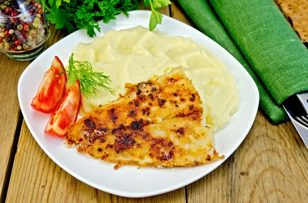 Stekt fisk med potatismos på ett bräde — Stockfoto