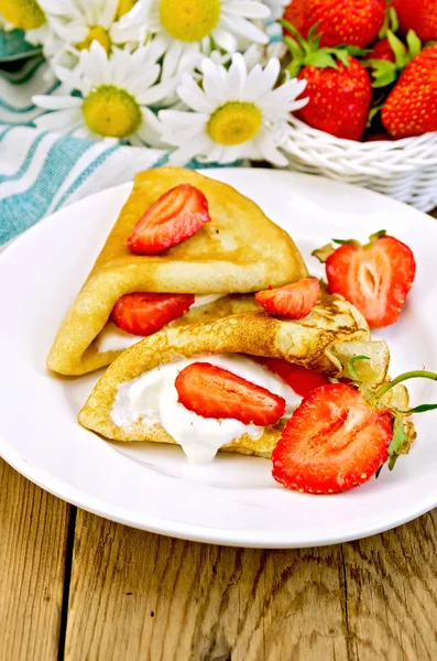 Pannkakor med jordgubbar och grädde i styrelsen — Stockfoto