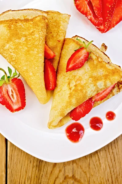 Pancakes with strawberries and jam on a white plate — Stock Photo, Image
