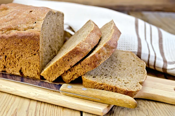Rye homemade bread sliced on the board with a napkin — Stock Photo, Image