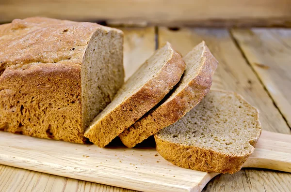 Rogge zelfgebakken brood gesneden op het bord — Stockfoto