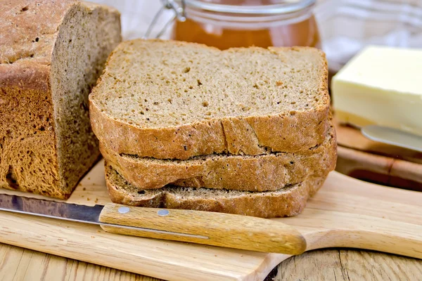 Домашний хлеб из ржи с медом и ножом — стоковое фото