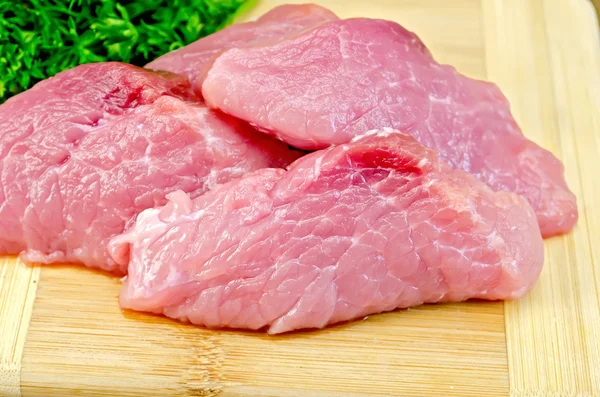Las rodajas de carne de cerdo en la tabla con las especias — Foto de Stock