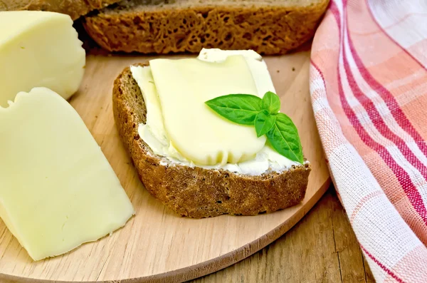 Sandwich with cheese suluguni and butter on board — Stock Photo, Image