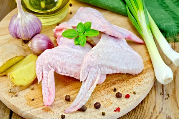 Chicken wings with garlic on a board — Stock Photo, Image