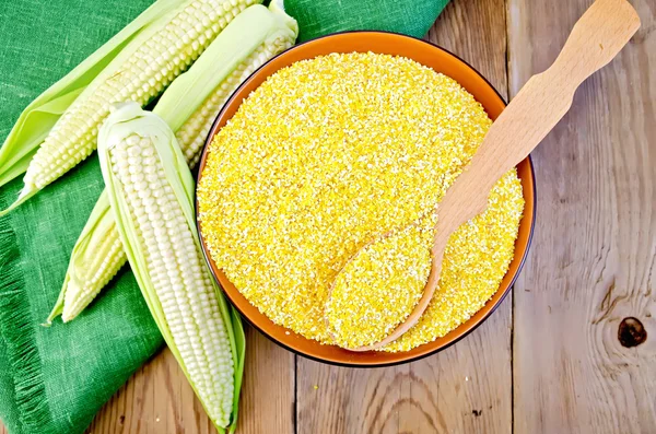Corn grits with corn cobs on a board — Stock Photo, Image