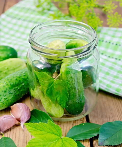 Komkommers in een pot met bladeren en Servet — Stockfoto