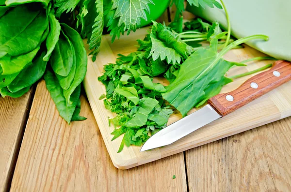 Sorrel e ortiche tagliate a fette sulla tavola con un coltello — Foto Stock