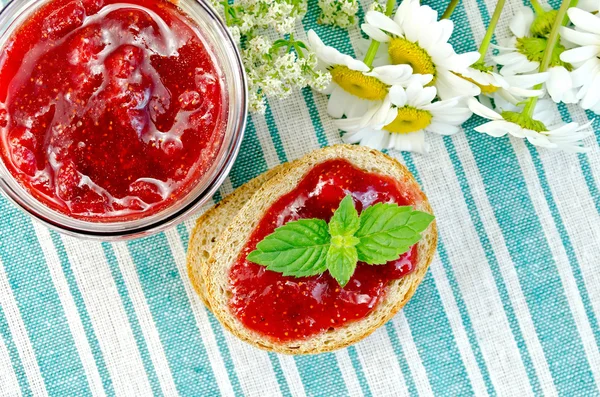 Bread with strawberry jam and daisies on napkin top — Stock Photo, Image