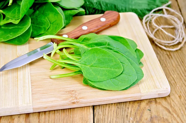 Espinacas en el tablero con un cuchillo — Foto de Stock