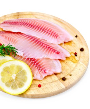 limon ve bir tahta üzerine dereotu tilapia filetosu