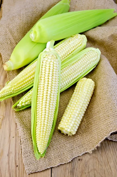 Mazorca de maíz en arpillera y tabla —  Fotos de Stock