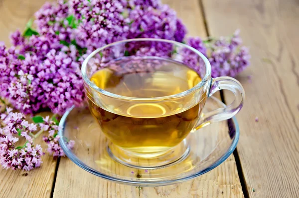 Gyógynövény tea oregánó egy üveg csésze a fedélzeten — Stock Fotó