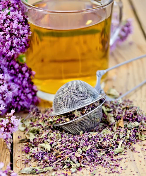 Herbal tea from oregano with strainer in glass mug — Stock Photo, Image