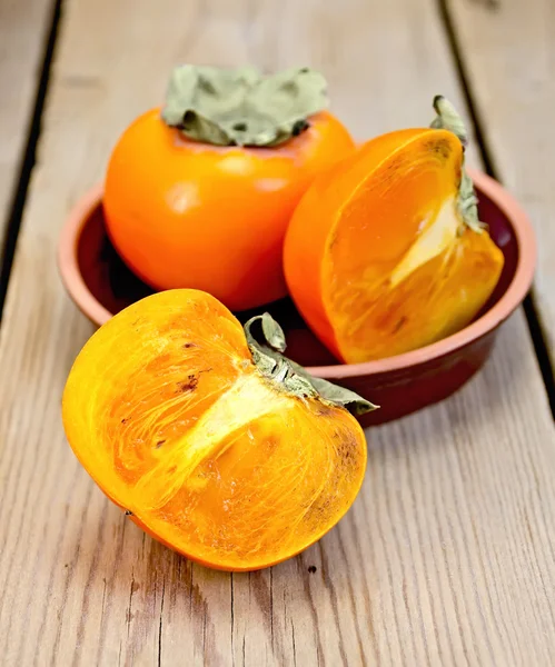 Persimmon on the board in pottery — Stock Photo, Image