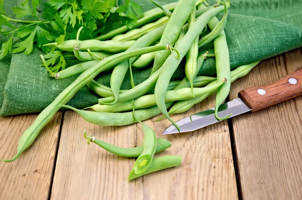 Bönor gröna i styrelsen med en kniv — Stockfoto