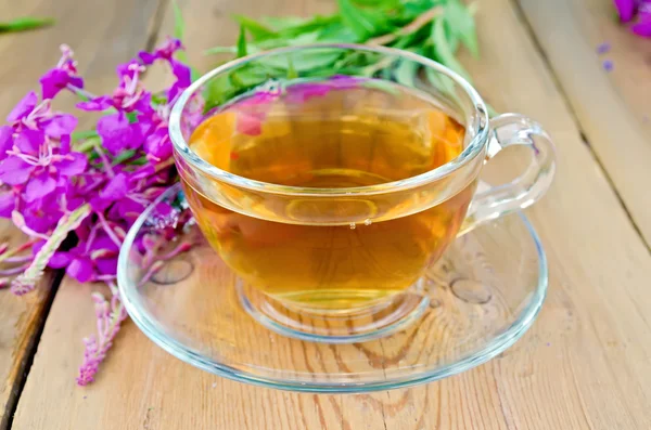 Herbal tea in glass cup of fireweed on board — Stock Photo, Image