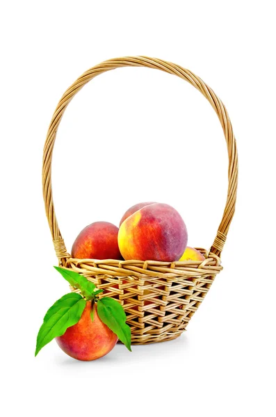 Peaches with leaves and basket — Stock Photo, Image