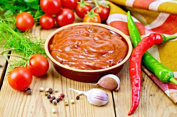 Ketchup in pottery with vegetables on board — Stock Photo, Image