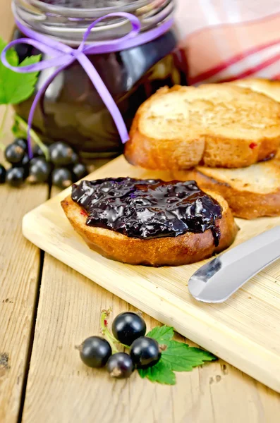 A fekete ribizli lekvár a táblán kenyér — Stock Fotó