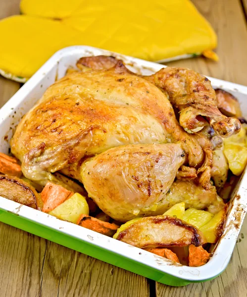 Hühnchen mit Gemüse an Bord und Topflappen gebacken — Stockfoto