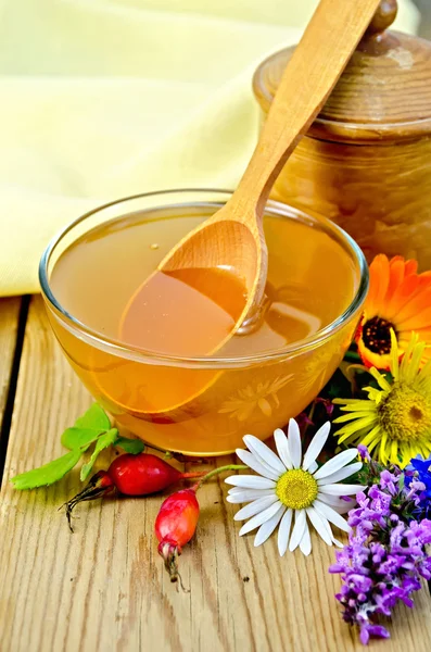 Honey with flowers and spoon on board — 스톡 사진