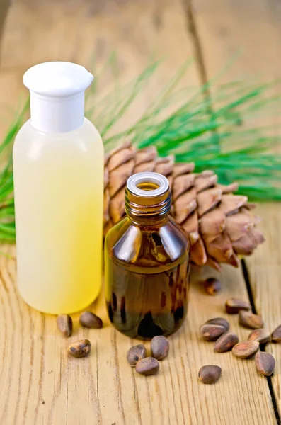 Öl und Lotion mit Zedernkegel an Bord — Stockfoto