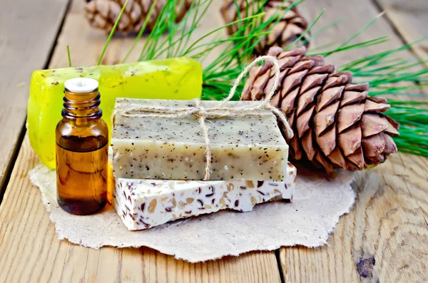 Aceite y jabón diferentes conos de cedro a bordo —  Fotos de Stock