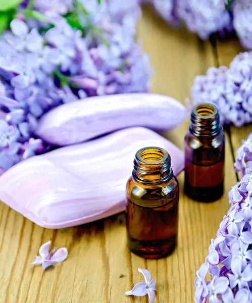 Aceite con jabón y lilas en el tablero — Foto de Stock